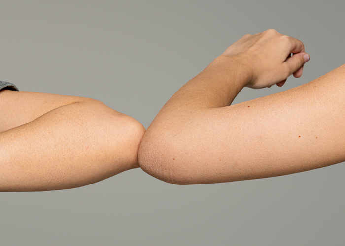 Applying lotion to arm, young woman in white tank top at home. Skincare, beauty, moisturizing, self-care, wellness, everyday routine
